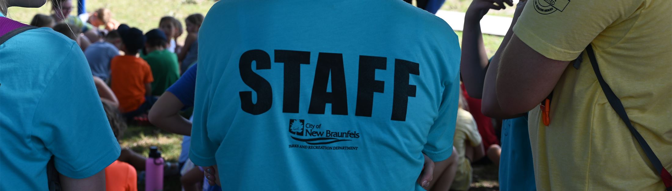 The back of an employee shirt that says STAFF in block letters