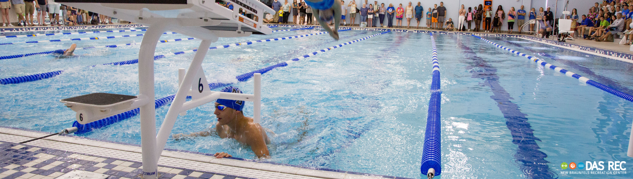 A swimmer participates in a swim meet at Das Rec