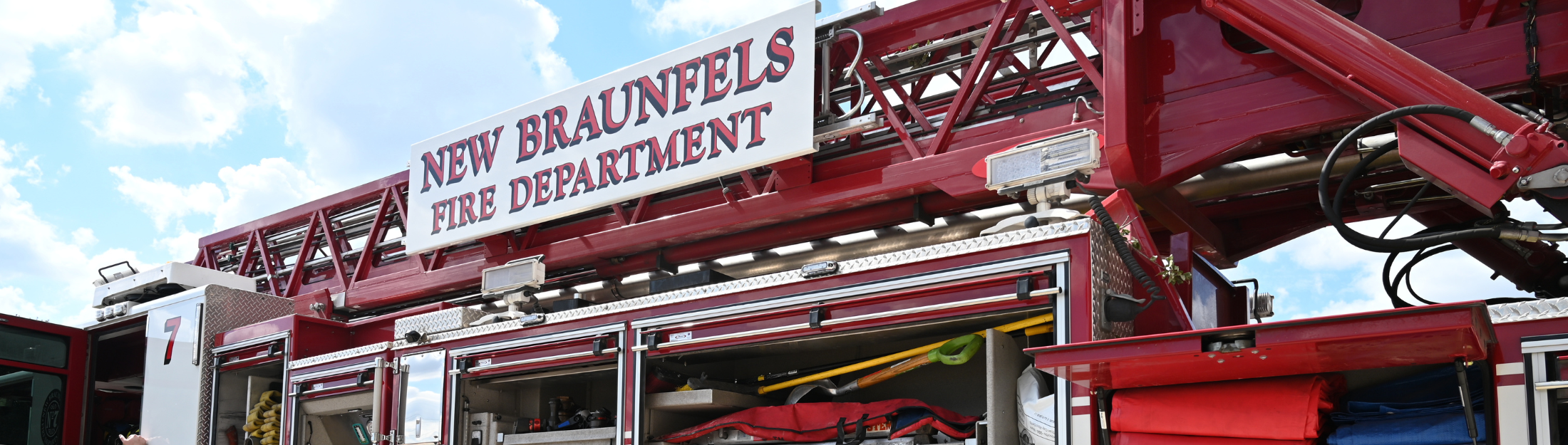 Fire Station 7 truck with open compartments and New Braunfels Fire Department sign