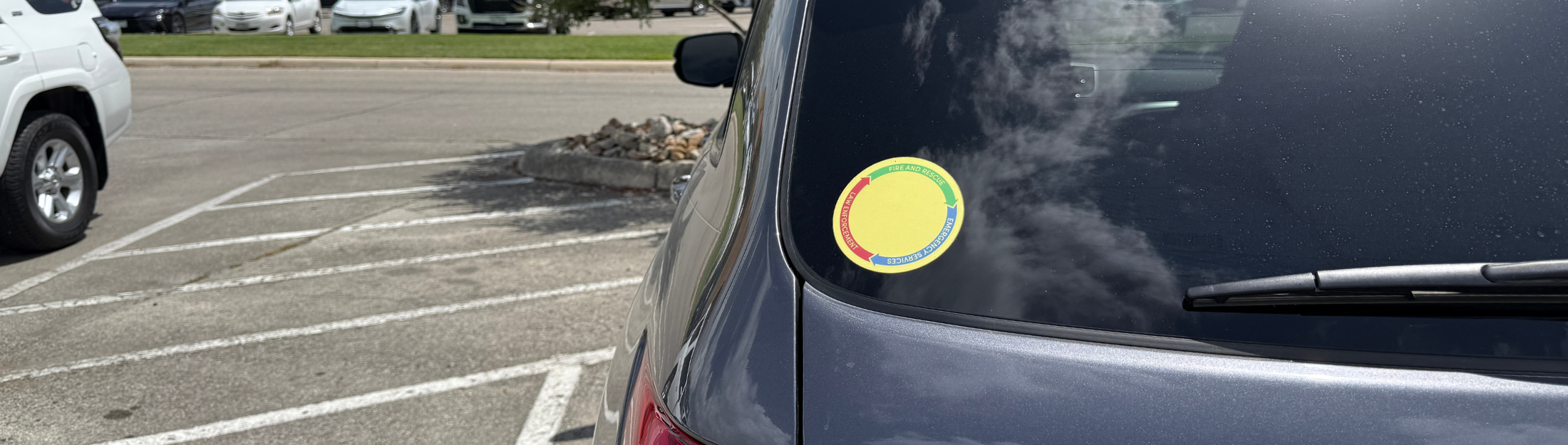 Car rear window with a Yellow Dot Sticker on it